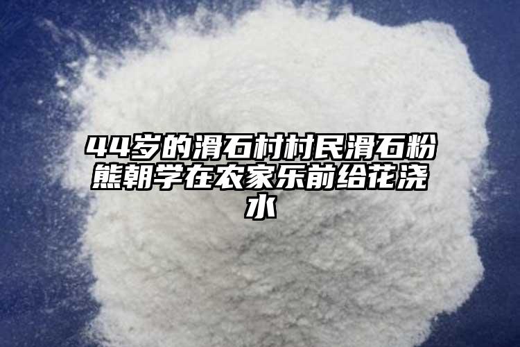 44岁的滑石村村民滑石粉熊朝学在农家乐前给花浇水